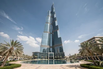 Vue en contre-plongée de la Tour Almas à Jumeirah Lakes Towers, Dubai, avec façade en verre et acier reflétant le ciel bleu